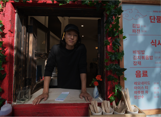 Video. First-person view as seen through Android XR glasses. A demonstration of how Android XR translation features work. Standing in front of a restaurant ordering window. The device translates spoken Korean. Then it translates a Korean menu into English.