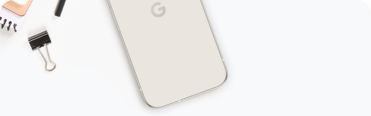A Google Pixel 9a next to a pencil, notepad, and binder clip.