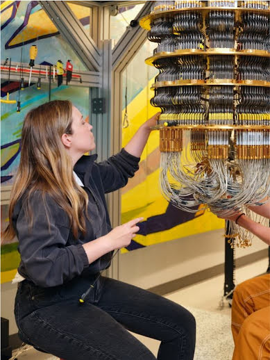 Eine Frau passt in einem Labor die komplexe Verkabelung eines Quantencomputers an.